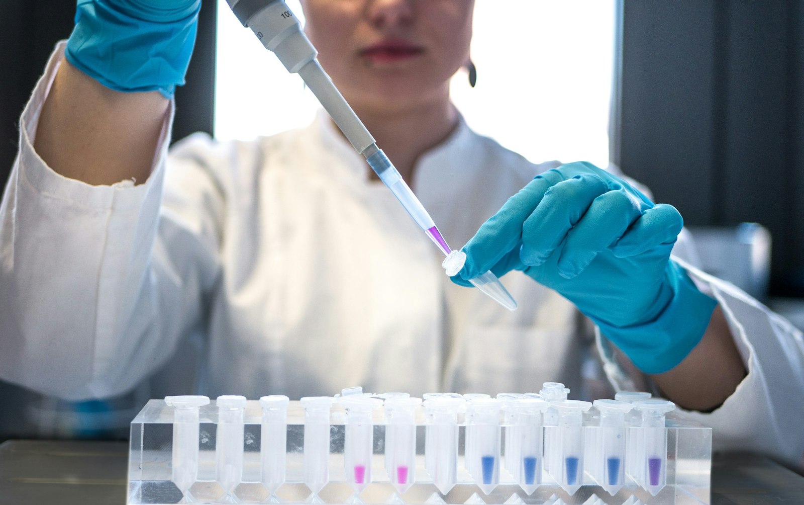 Scientist using a pipette with test tubes in a lab