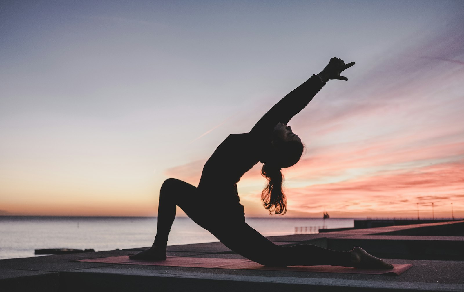 Silhouette of a woman doing yoga at sunset